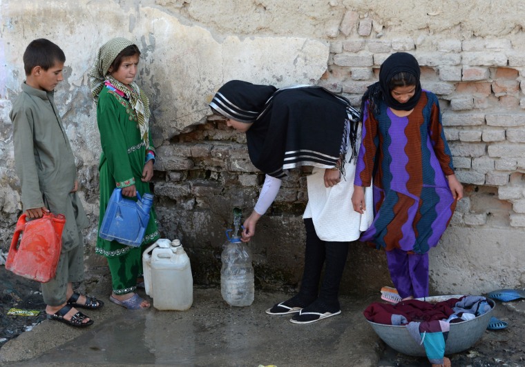 Image: Aziza Rahimzada, (second-from-right), collects water along with other children who live in her encampment in Kabul.