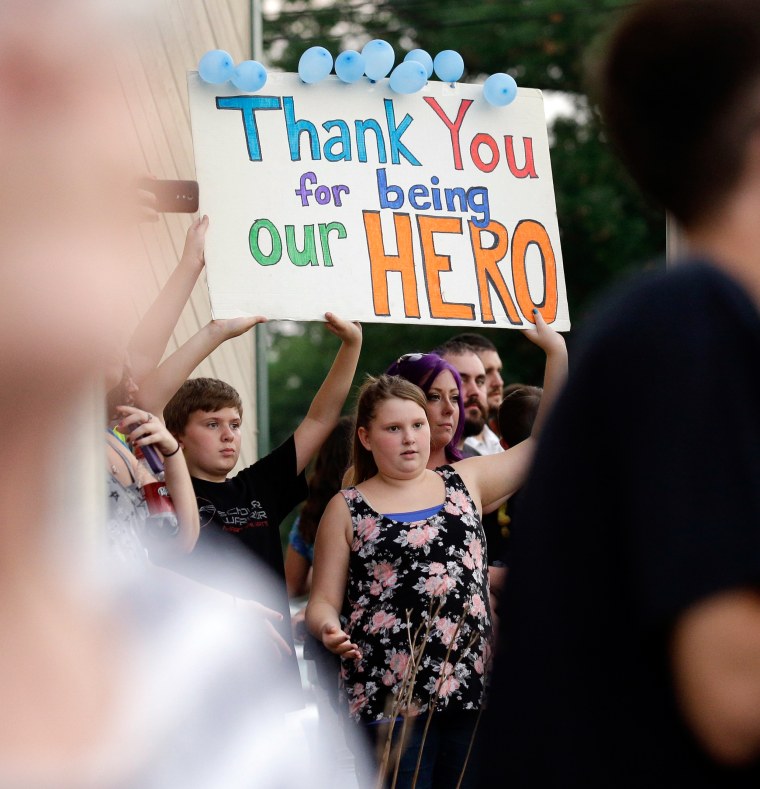 Image: Mourners hold a sign during a vigil at Lakefront Park