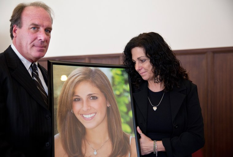 Image: Jim Burk, left, and Viviane Guerschon, right, hold a portrait of their daughter Lauren Burk