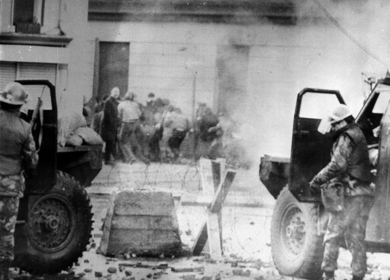 Image: Soldiers take cover behind their armored cars