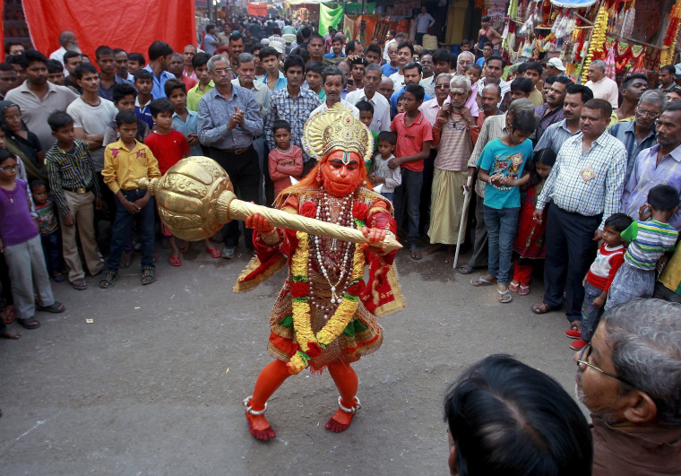 Image: A man dressed as Hindu monkey god Hanuman performs on a street during Hanuman Jayanti Festival in Allahabad