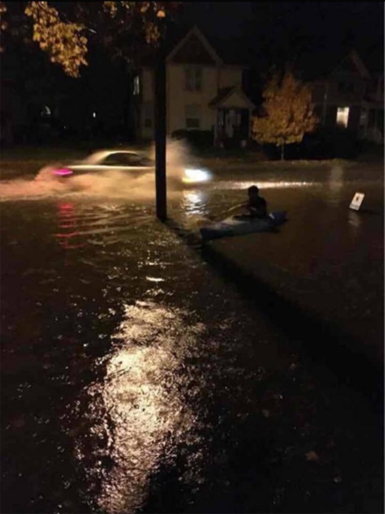 Image: A man pictured kayaking along Church Street in Iowa City.