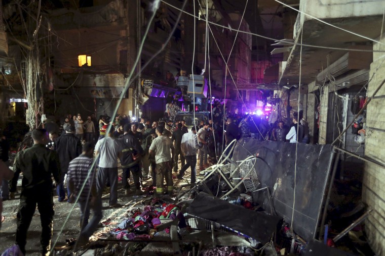 Image: Residents inspect a damaged area caused by two explosions in Beirut's southern suburbs, Lebanon