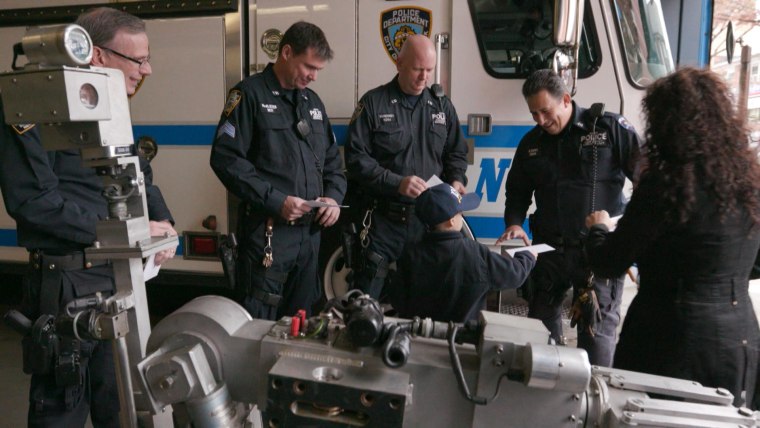 Zachary Becerra passes out thank-you cards to officers at New York’s 109th Precinct in Queens.