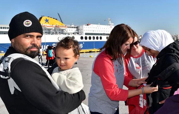 More than 9,000 refugees arrive on Greek shores daily, and 30 percent of them are children. Fleeing violence and forced from their homes, some families will walk hundreds of miles to find safety in Europe. Here, Carry The Future volunteers help fit refugees with baby carriers.