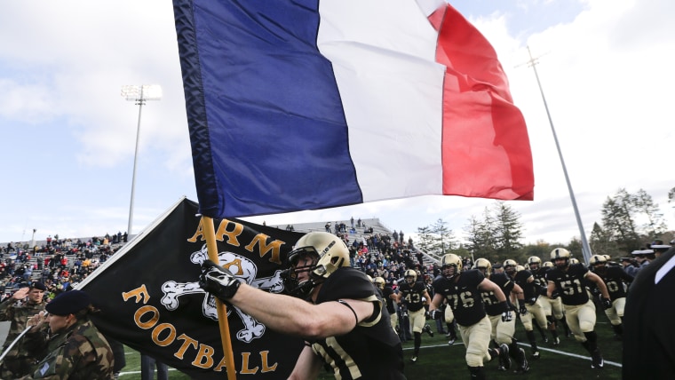 Army defensive back Caleb McNeill carries the flag of France onto the field before an NCAA college football game against Tulane, Saturday, Nov. 14, 2015, in West Point, N.Y.