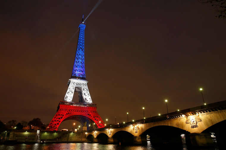 Image: The Eiffel Tower is lit with the blue, white and red colours of the French flag in Paris to pay tribute to the victims of a series of deadly attacks in the French capital