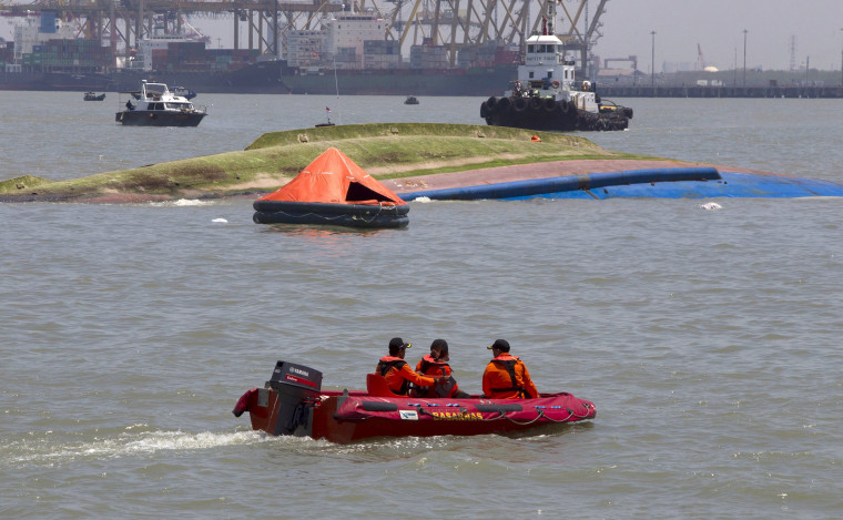 Image: A search and rescue team patrols near the ferry KM Wihan Sejahtera after it capsized in the port of Tanjung Perak, Surabaya, East Java