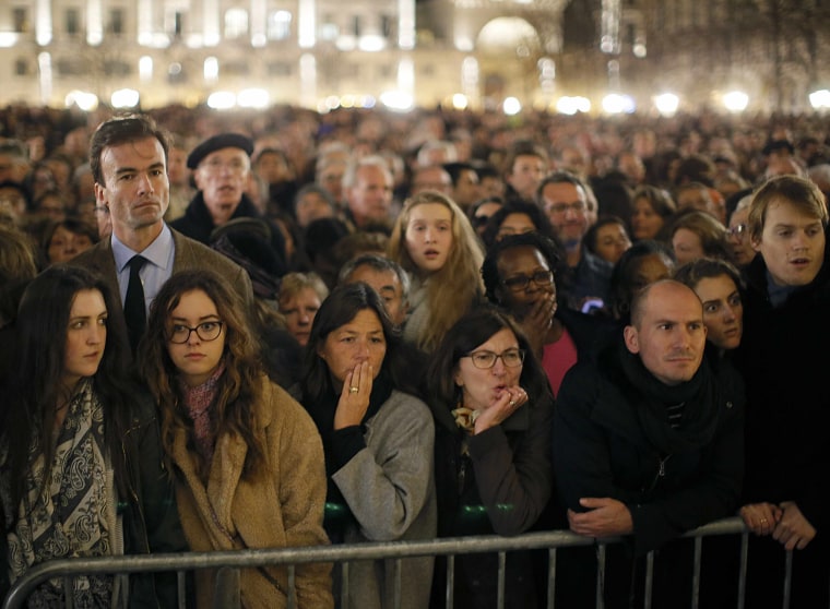 Image: People gather outside Notre Dame Cathedral where a mass is held following a series of deadly attacks in Paris