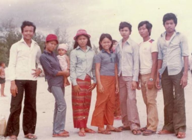 Lundy Khoy (baby on left), was born in a refugee camp in Thailand. This photo shows her with her her father (far left), mother (holding Lundy), and their brothers and sisters at the camp.