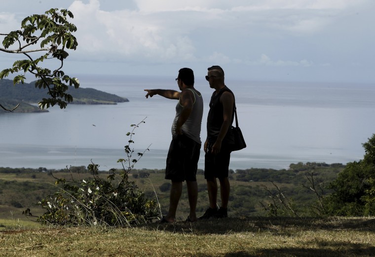 Image: Two Cuban migrants look towards the sea in the town of La Cruz near the border between Costa Rica and Nicaragua