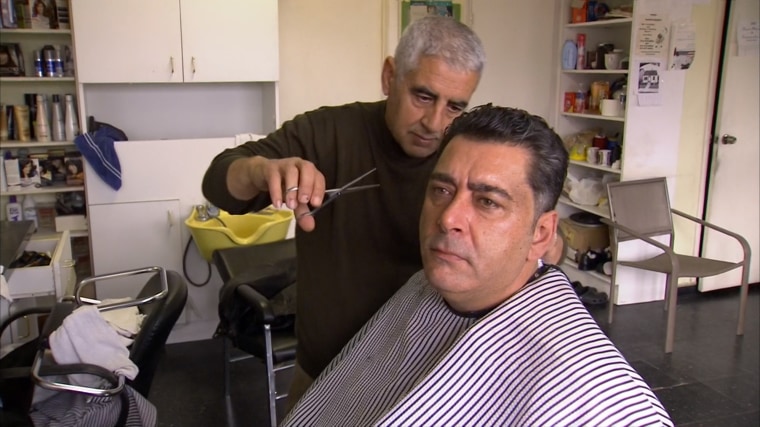 Hicham Diwal sits for a haircut in Dearborn, Mich. Diwal immigrated to the U.S. three decades ago.