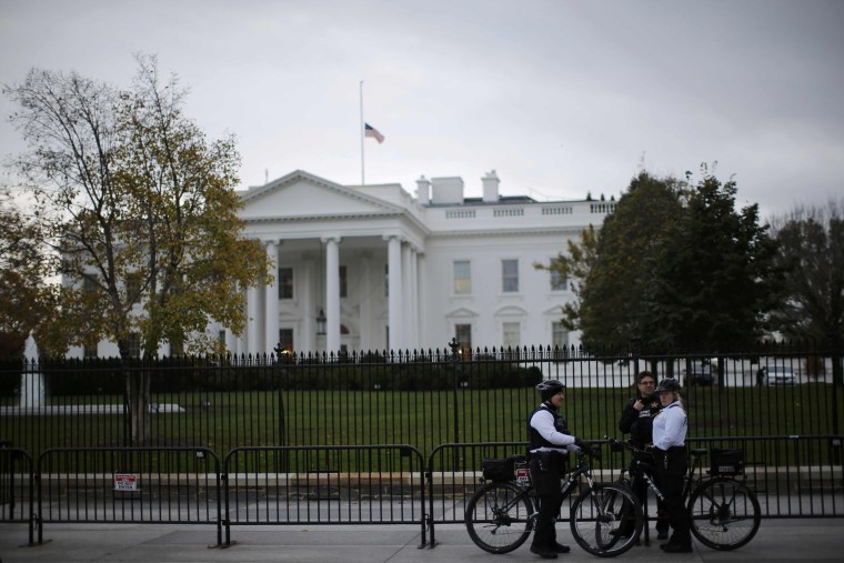 Image: Uniformed U.S. Secret Service officers keep watch outside the White House in Washington
