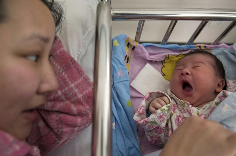 Image: Li Yan looks at her newborn baby at a hospital in Hefei