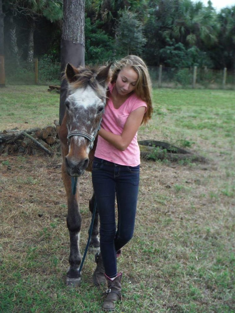 A girl hugs an old horse named Barney the day before he passed away.