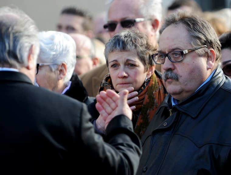 Image: An attendant speaks to Sylvie Lieffrig-Petard and her husband Erick Lieffrig-Petard