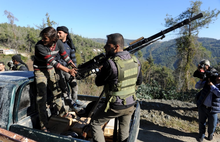 Image: Syrian Turkmen fighters are seen with an anti-aircraft artillery weapon near the northern Syrian village of Yamadi, near the Turkish-Syrian border, Syria