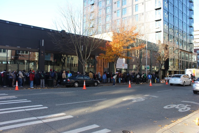 A line of people wait outside the shelter for the volunteer services to begin.