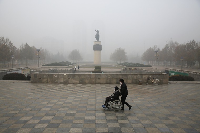 Image: A woman is pushed in a wheelchair in Baoding, China