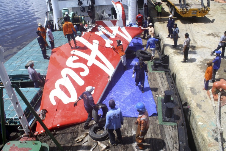 Image: File photo of a section of AirAsia flight QZ8501's tail being loaded onto a boat 