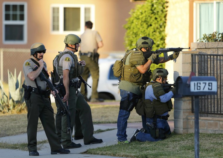 Image: Police officers conduct a manhunt after a mass shooting in San Bernardino