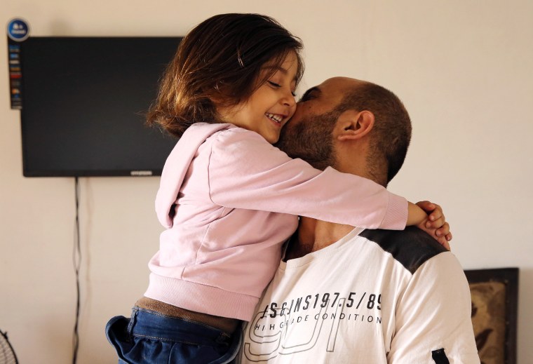 Image: Abdul Halim al-Attar, kisses his daughter Reem, 4, at their house in Lebanon.