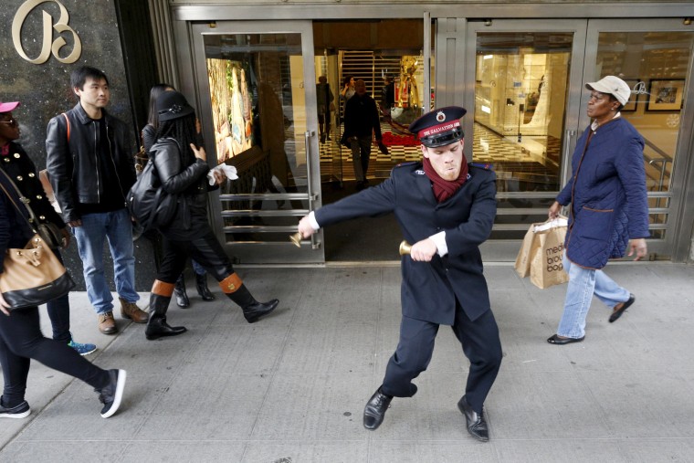 Image: Salvation Army Bell Ringer Nate Hinzman dances for Black Friday shoppers outside Bloomingdales department in the Manhattan borough of New York