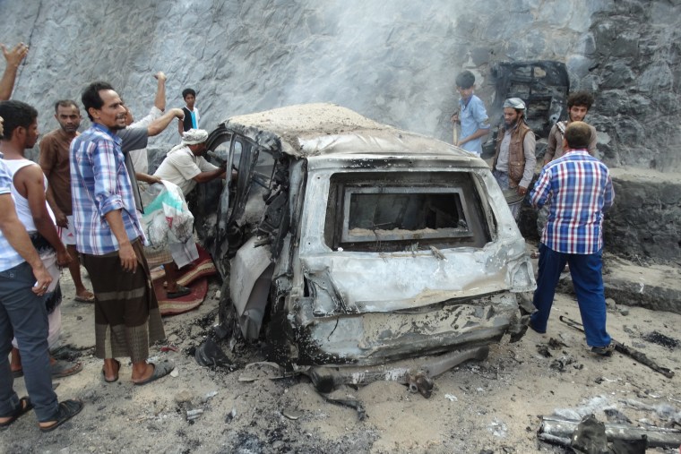 Image: Yemenis inspect the scene of a car bomb attack