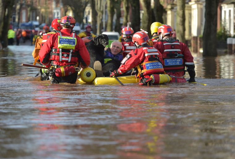 Image: A rescue team helps to evacuate people from their homes