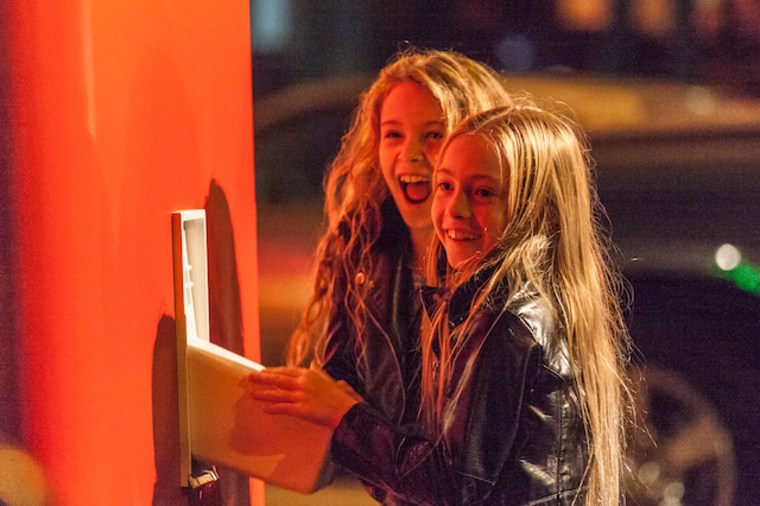 Two girls try out the giant switch used for Improv Everywhere's 2015 holiday prank.