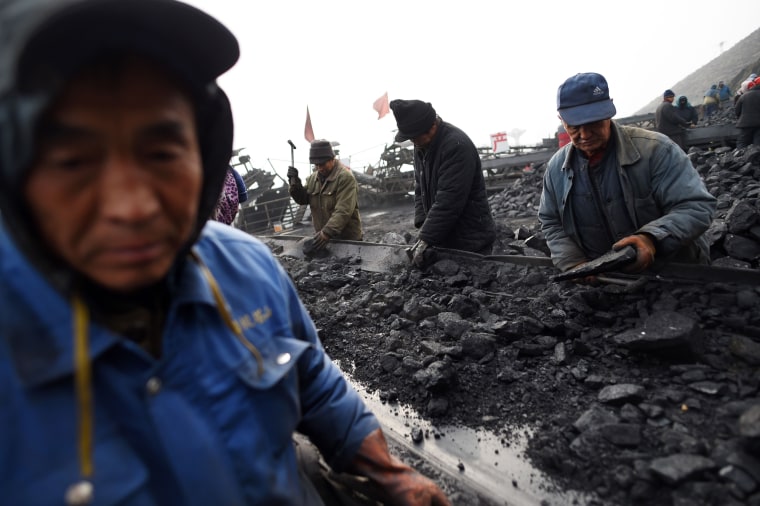 Image: Workers sort coal on a conveyor belt, near a mine in Datong, China
