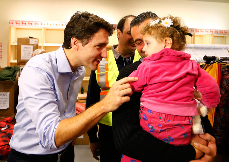 Image: Syrian refugees are greeted by Canada's Prime Minister Justin Trudeau