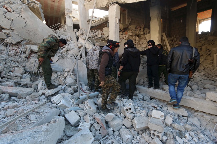 Image: YPG fighters inspect damage at a site hit by one of three truck bombs