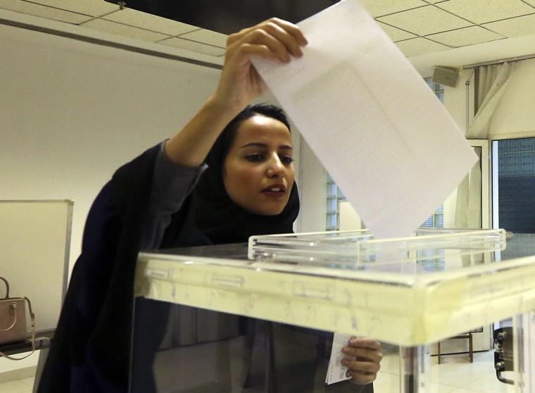 A Saudi woman casts her ballot at a polling center during municipal elections in Riyadh, Saudi Arabia, Saturday, Dec. 12, 2015. Saudi women are heading to polling stations across the kingdom on Saturday, both as voters and candidates for the first time in this landmark election.