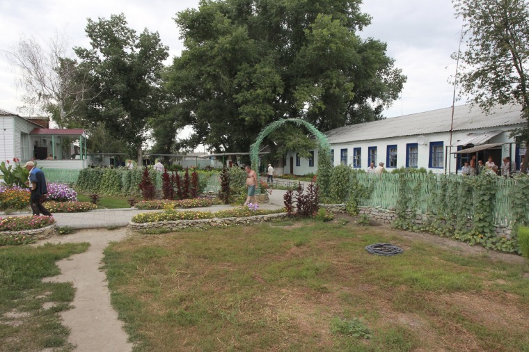 Image: People walk near the buildings of the Novokhopersky Neuropsychiatric Home in the village of Alferovka in the Voronezh region, Russia,