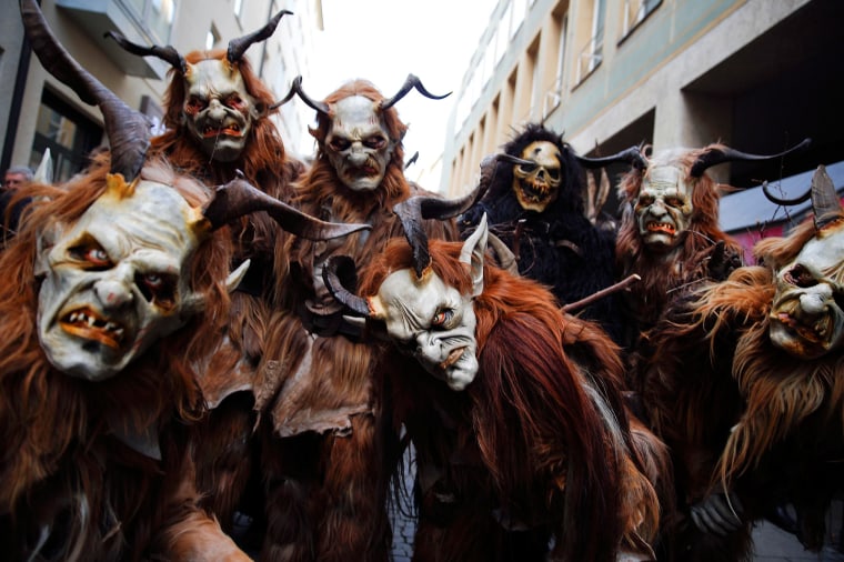 Image: Men dressed as 'Krampuss' prepare to parade at Munich's Christmas market