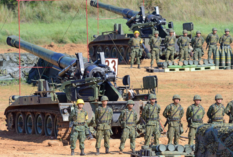 Image: Taiwan military soldiers stand guard next to a 155-millimeter howitzer