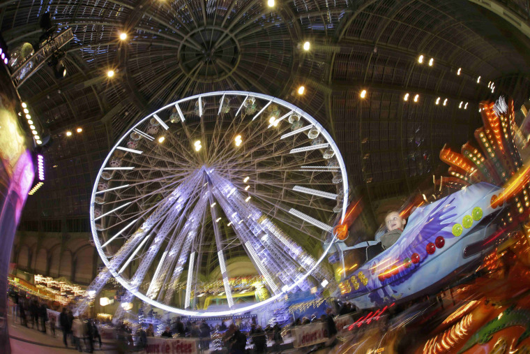 Image: People enjoy rides at the funfair \"Jours de Fetes\" inside the Grand Palais in Paris