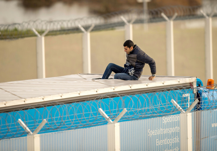 Image: A migrant or refugee enters the trailer of a truck