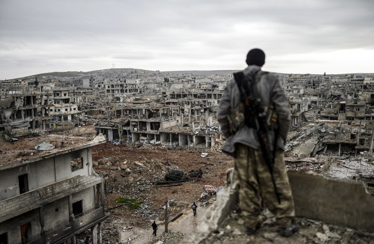 Image: Musa, a 25-year-old Kurdish marksman, stands atop a building