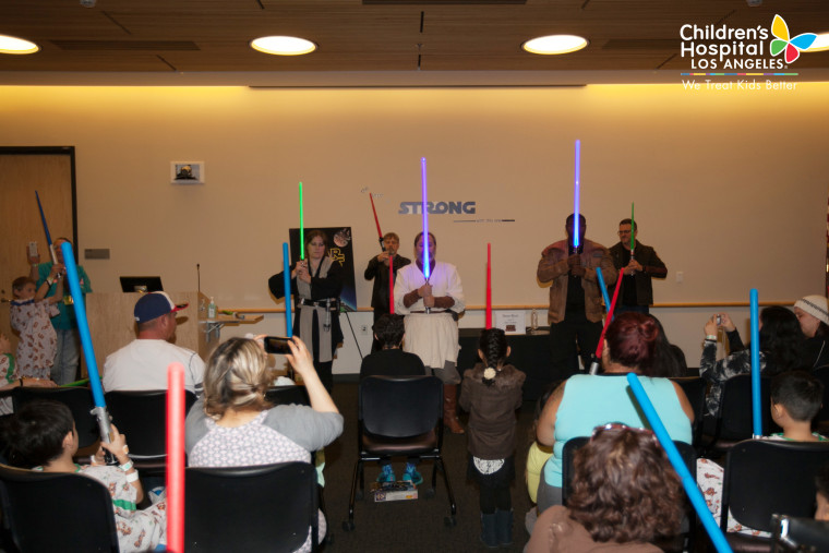 "Star Wars" star Mark Hamill, against the wall in the back, gets reacquainted with a light saber during a visit to Children's Hospital Los Angeles on Dec. 4, 2015.