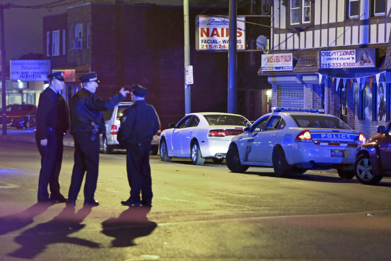 Investigators gather at the scene where a Philadelphia police officer shot and killed a man during a traffic stop in 2014.