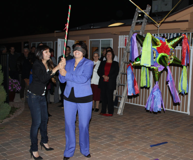 Griselda Nevarez (left) spinning her blindfolded mother right before she hits the piñata, part of the family's cherished Christmas traditions.