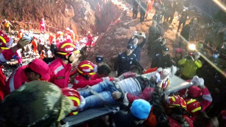 Image: Rescuers take out the first survivor of the landslide in Shenzhen