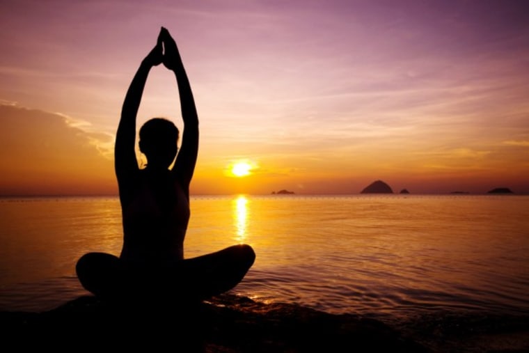 Mom stretches outside while watching sunrise.