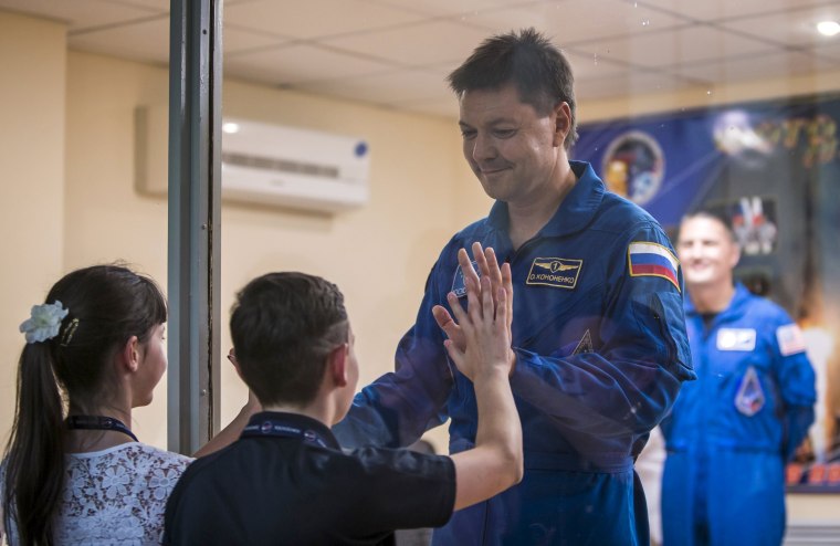 Image: The International Space Station crew member Kononenko of Russia interacts with his children as he stands behind a glass wall at a news conference at the Baikonur cosmodrome in Baikonur