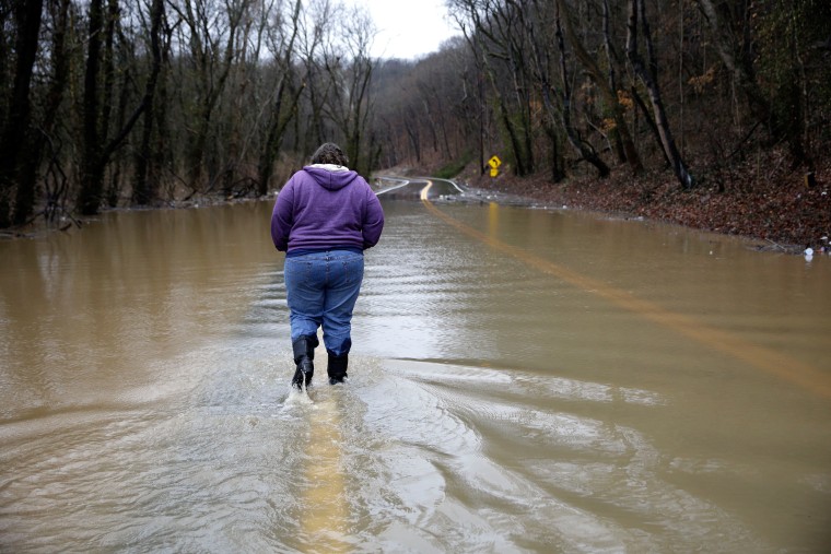 Image: Tammy Poirrier walks down a flooded road