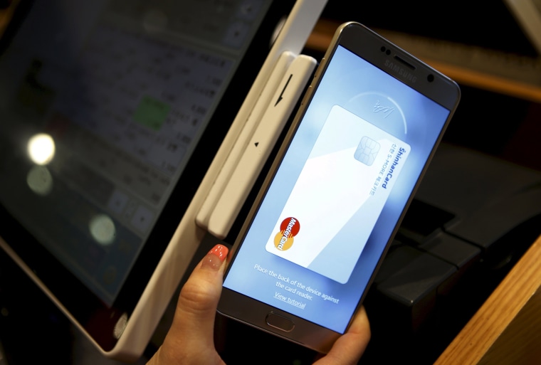 Image: File photo of an employee demonstrating a Samsung Pay, Samsung's new mobile payment system at a shop in Seoul