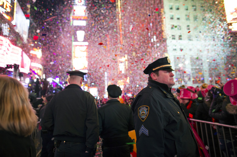 New York City police officers stand among the falling confetti just after midnight in Times Square during New Year's Eve festivities on Jan. 1, 2015.