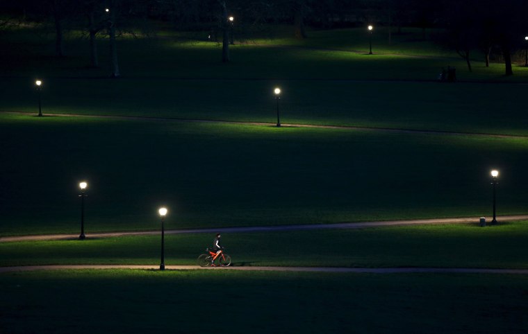 Image: A cyclist rides through Primrose Hill in the early evening in London
